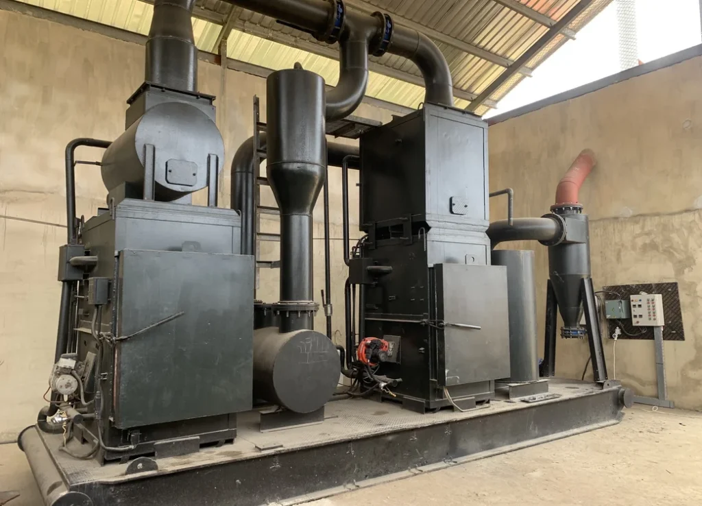 Industrial waste-to-energy incinerator system with thermal conversion chambers and exhaust pipes installed at Nigerian facility for renewable power generation